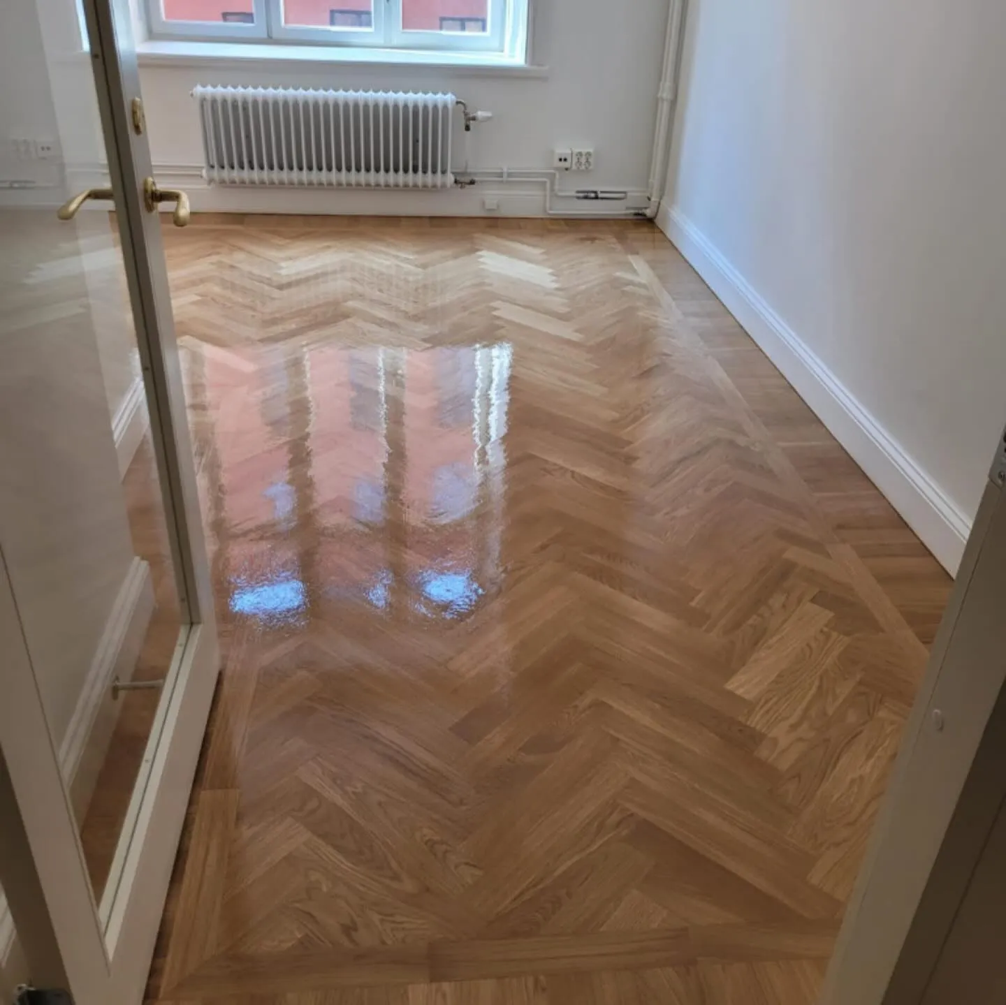Bild av en hantverkare som utför underhåll på ett oljat trägolv, applicerar olja för att bevara ytan och förnya glansen. - Anpassade träkonstruktioner - Snickeri Stockholm