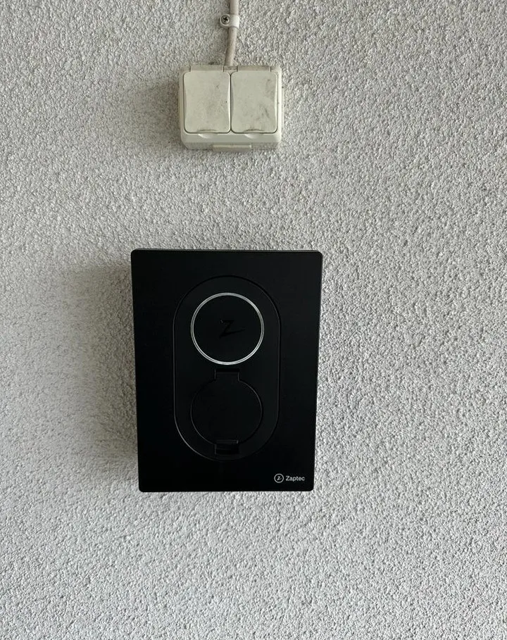 En elektriker installerar ett eluttag på en vägg i ett modernt hem för att säkerställa säker och effektiv användning av el.