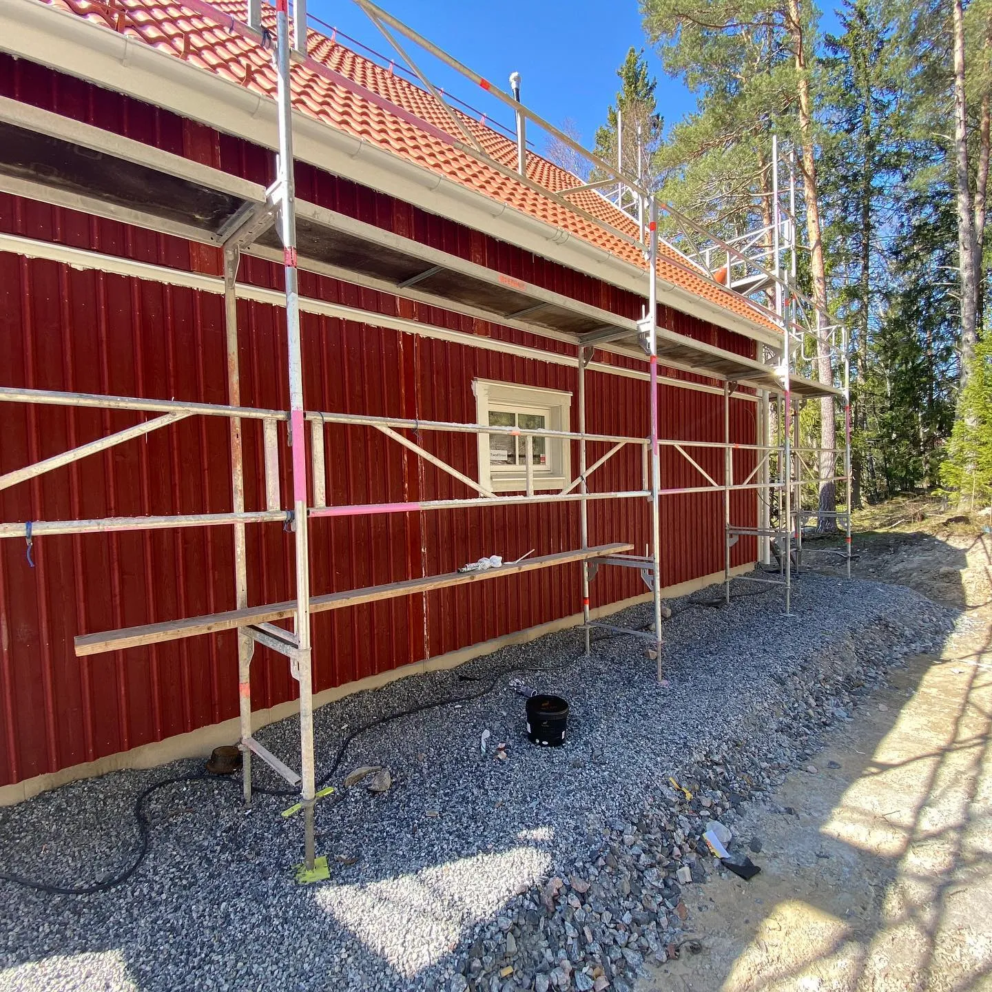 Bild av en person som förbereder en fasad för utomhusmålning, med fokus på viktiga steg för hållbar utomhusfärg och praktiska tips för att måla huset själv.