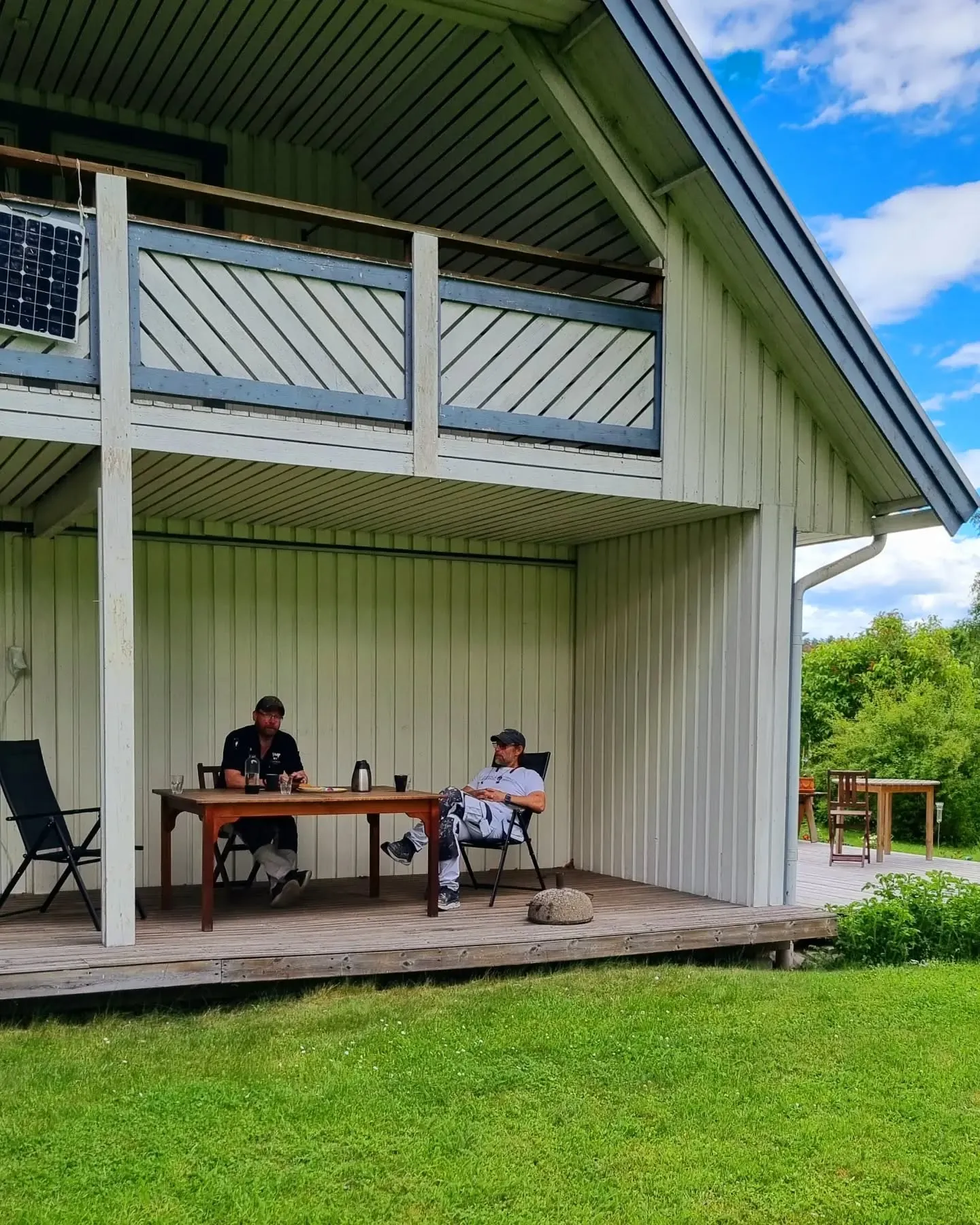 En vacker uteplats med trädgårdsbyggnationer, inklusive altaner, skapad av professionella snickare för en trivsam utemiljö.